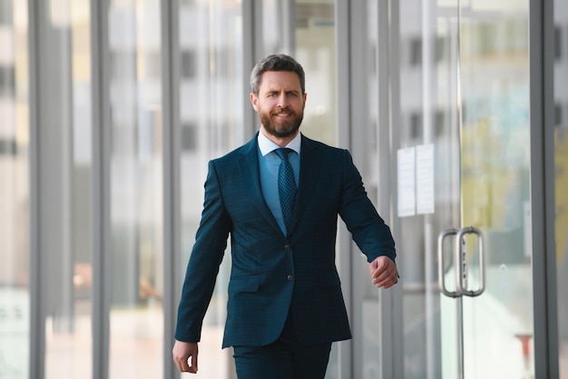 Businessman walking in city confident and successful handsome business man while walking outdoors ne