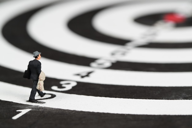 businessman walking on dartboard target center idea of financial and business goal