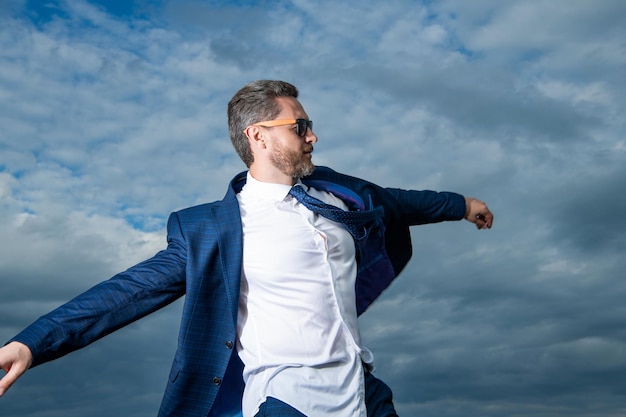 Businessman walking in open suit jacket fluttering in carefree wind carefree businessman