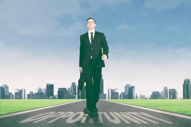 Businessman walking above opportunity word on the road