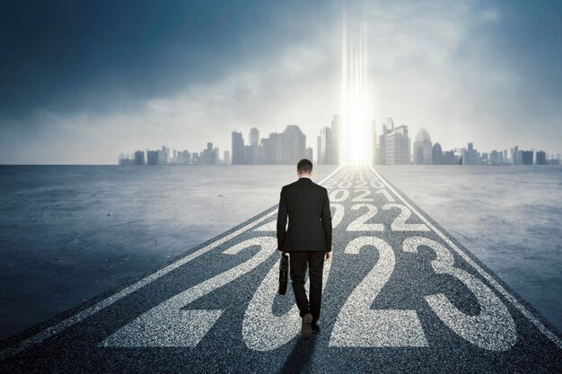 Businessman walking in the road with 2023 number