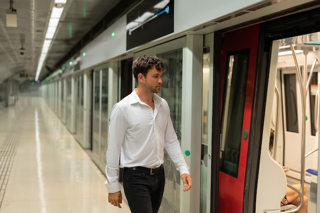 Uomo d'affari che cammina alla stazione della metropolitana