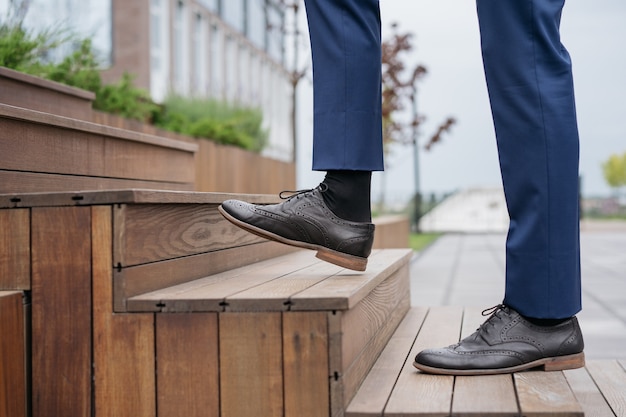 Foto l'uomo d'affari che cammina al piano di sopra si concentra sulla scarpa in pelle avvio di una carriera aziendale di successo concept