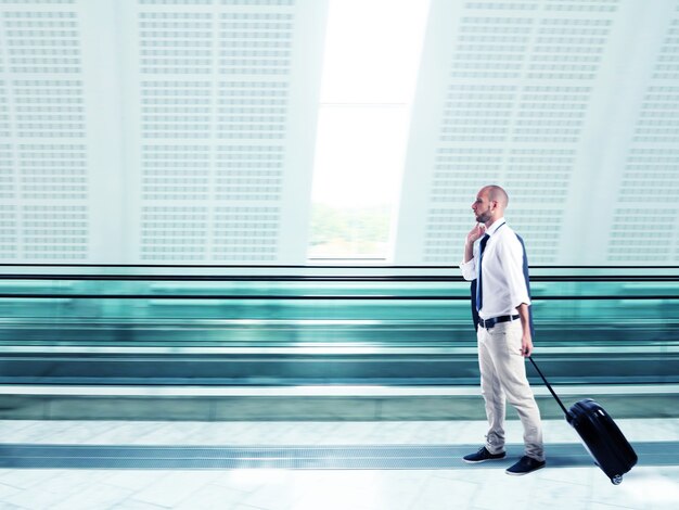 Photo businessman walking with trolley at the airport