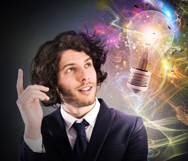 写真 描かれた電球を見て、新しい創造的なアイデアを考えるビジネスマン