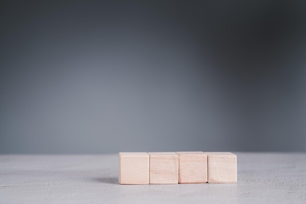 Uomo d'affari che indossa una camicia blu che dispone i blocchi di legno vuoti con le mani che è posizionato su un tavolo di legno bianco strategia aziendale e piano d'azione spazio di copia