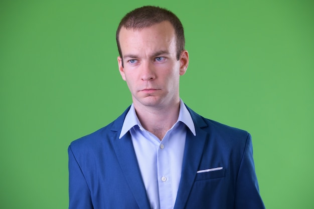 businessman wearing blue suit against green space