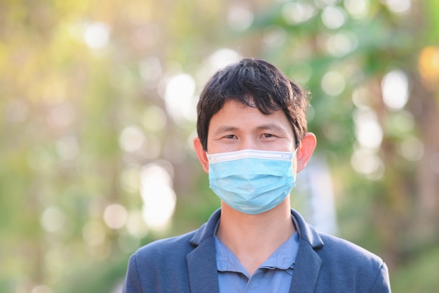 Businessman wearing a cloth mask in public area protect himself from risk of disease, people prevent infection from coronavirus Covid-19