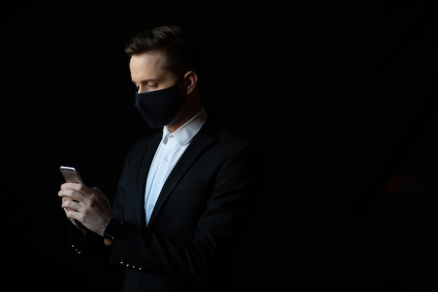 Businessman wearing face mask checking his smartphone