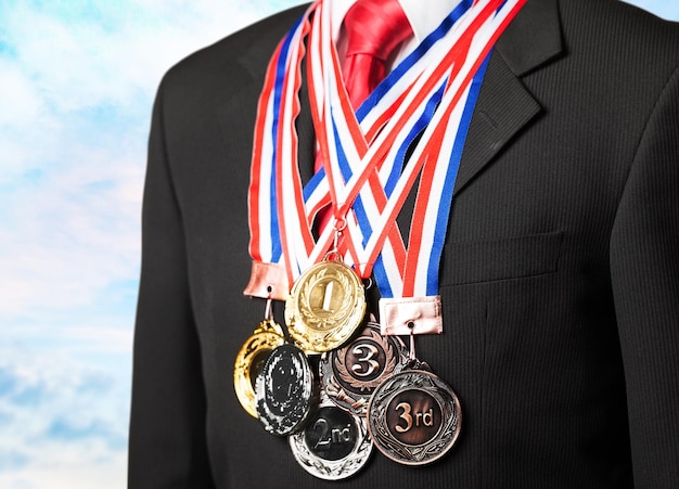 Businessman wearing formal suit and sport medals on background