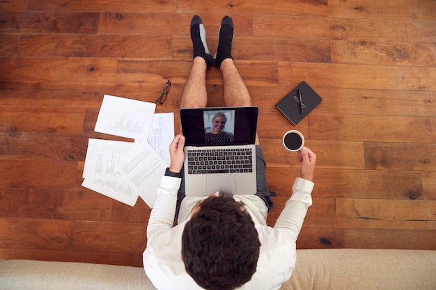 Businessman Wearing Loungewear And Shirt And Tie For Video Call On Laptop Working From Home