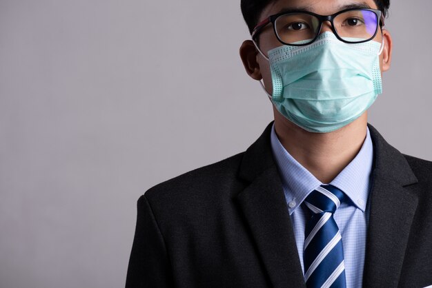 保護フェイスマスク、コロナウイルスとpm 2.5の戦いの概念を着ているビジネスマン。
