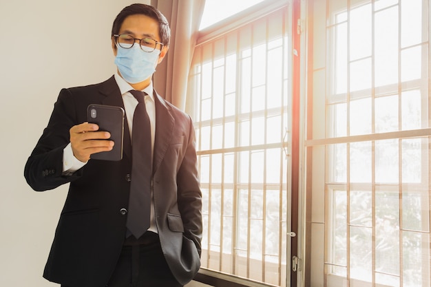 Photo businessman wearing protective mask using mobile phone