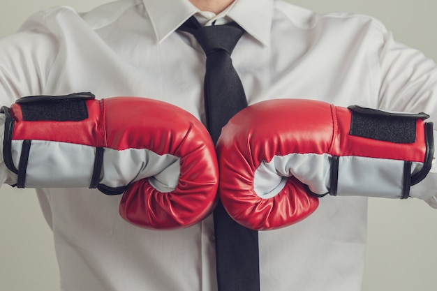 Businessman wearing red boxing bumping his fists together