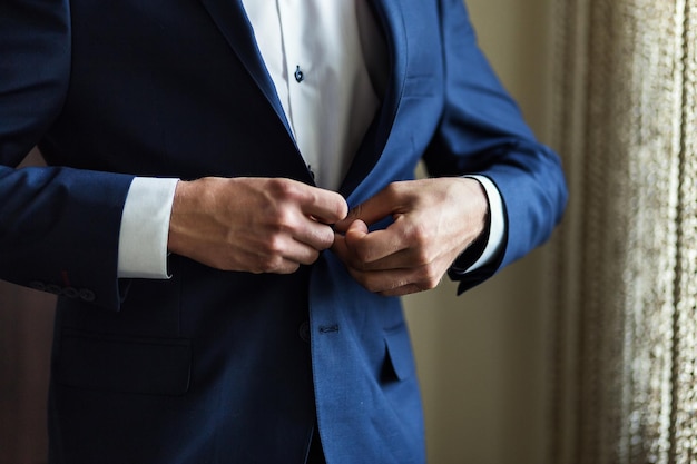 Photo businessman wears a jacketmale hands closeupgroom getting ready in the morning before wedding ceremony