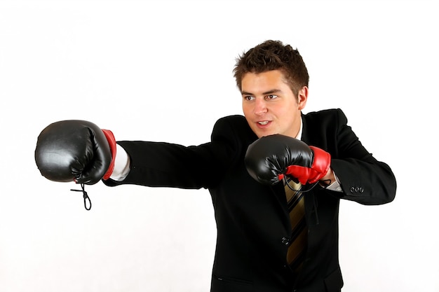 Businessman over white boxing in suit with red gloves