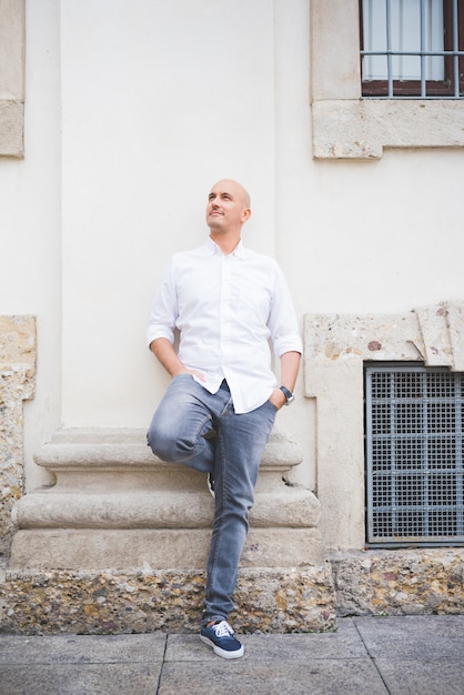 Businessman in white shirt leaning on wall