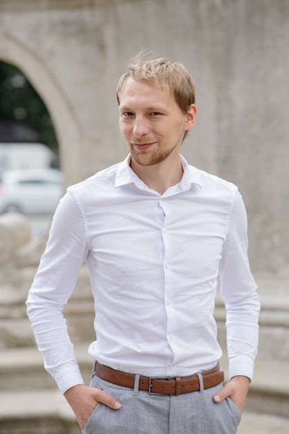 Uomo d'affari in una camicia bianca per le strade della città vecchia