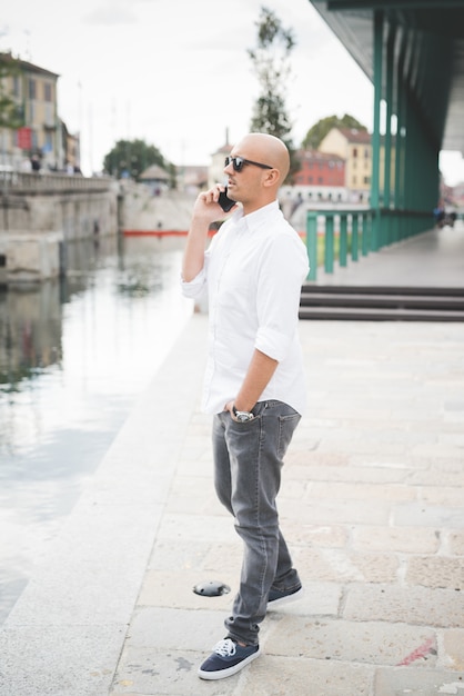 Businessman in white shirt with black sunglasses talking on the phone 