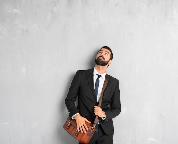 Businessman with beard looking up with serious face