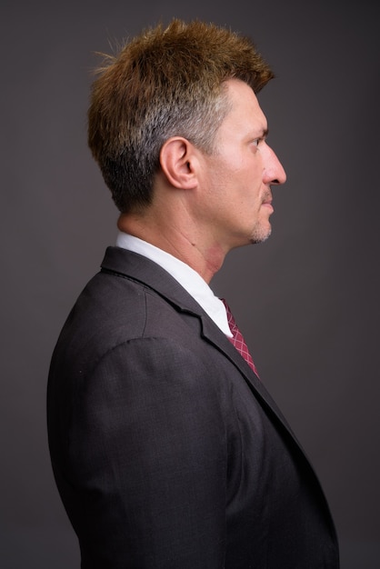 Businessman with blond hair against gray wall