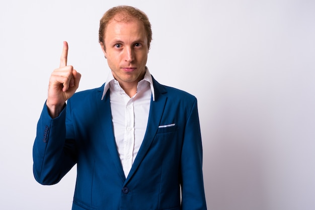 businessman with blond hair wearing blue suit against white space