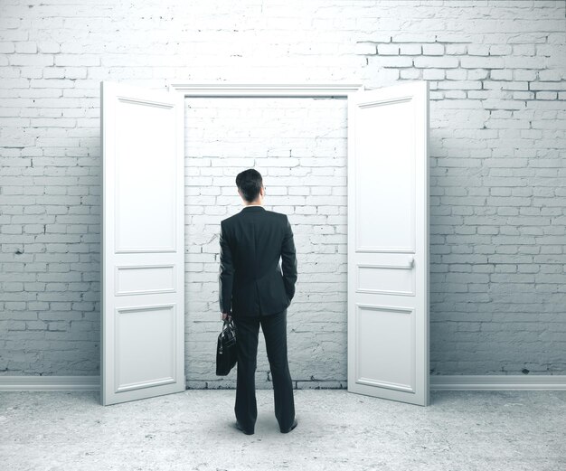 Photo businessman with briefcase standing in brick room