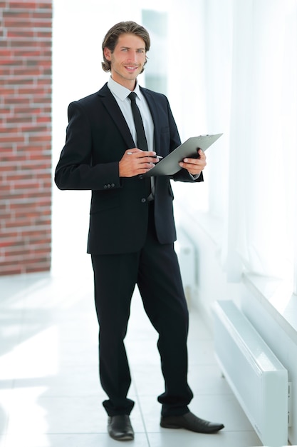 Businessman with business document standing in office