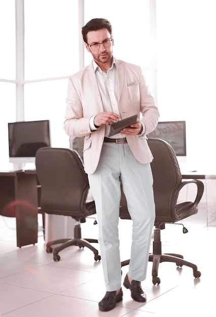 Businessman with calculator standing in an empty office