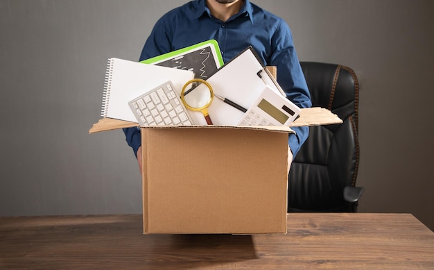 Бизнесмен с картонной коробкой и бизнес-объектами Потеря работы Безработица