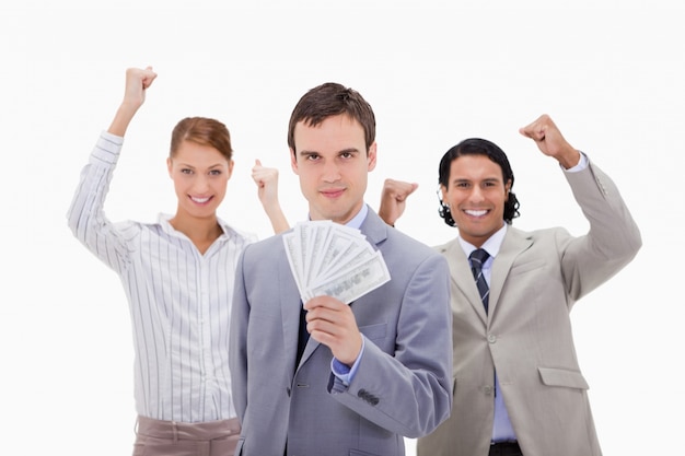 Businessman with cheering colleagues and money