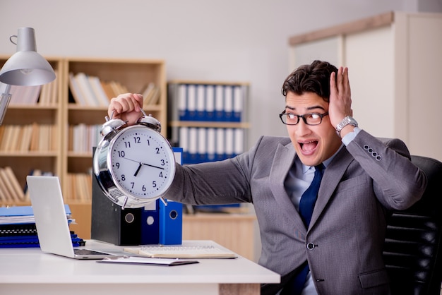 Businessman with clock failing to meet deadlines