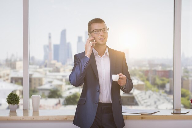 Businessman with coffee on phone