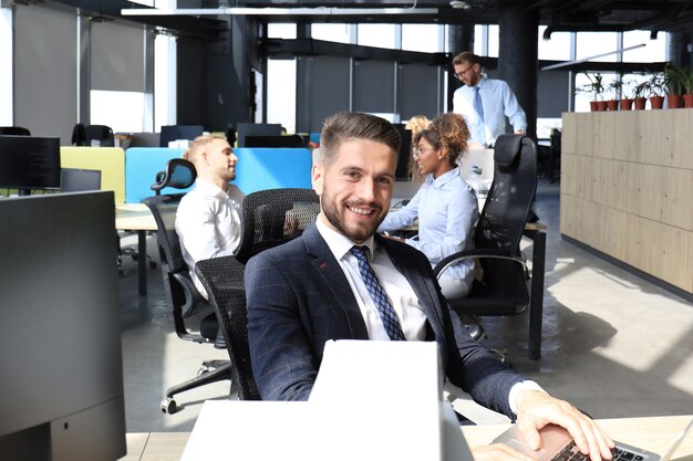 Businessman with colleagues in the background in modern office.