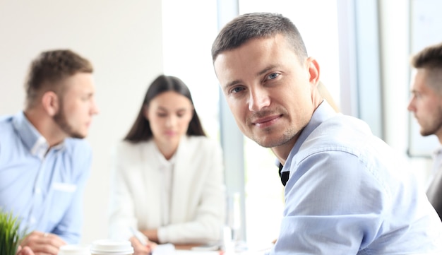 Businessman with colleagues in the background in office.