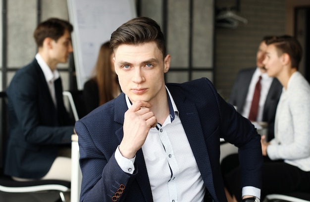 Businessman with colleagues in the background in office