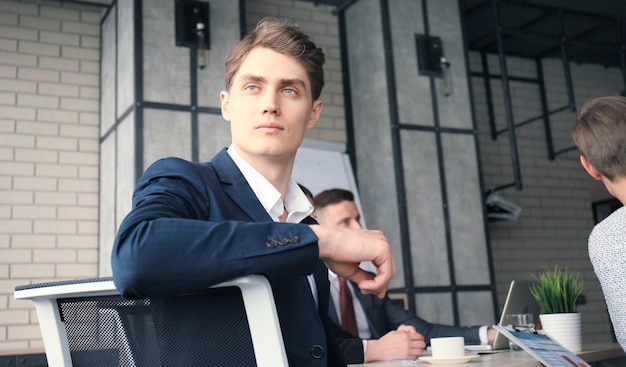 Businessman with colleagues in the background in office