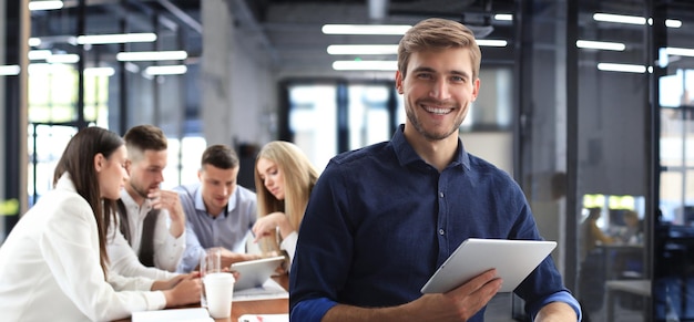 Businessman with colleagues in the background in office