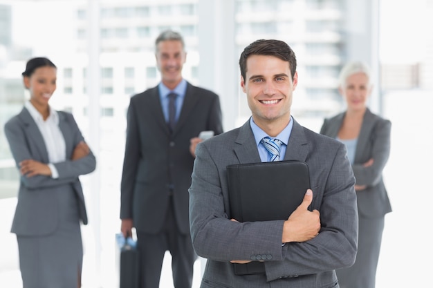 Businessman with colleagues behind in office