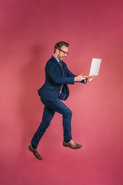 Businessman with computer jumping