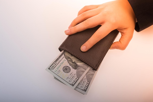 Businessman with dollar banknotes and wallet on white background