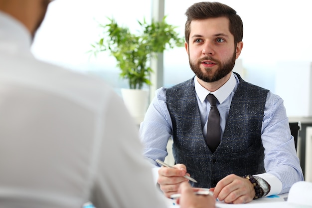 Photo businessman with financial graph and silver pen in arm solve and discuss problem with colleague