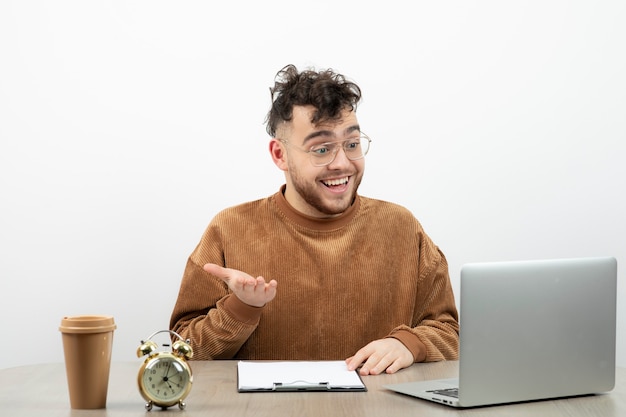 Businessman with the glasses sitting and having business call on laptop. 