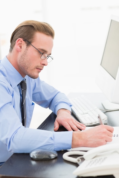 Businessman with glasses taking notes