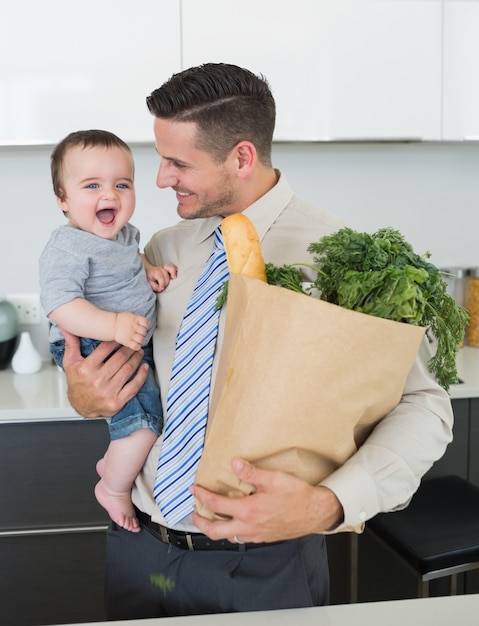 Businessman with grocery carrying baby 