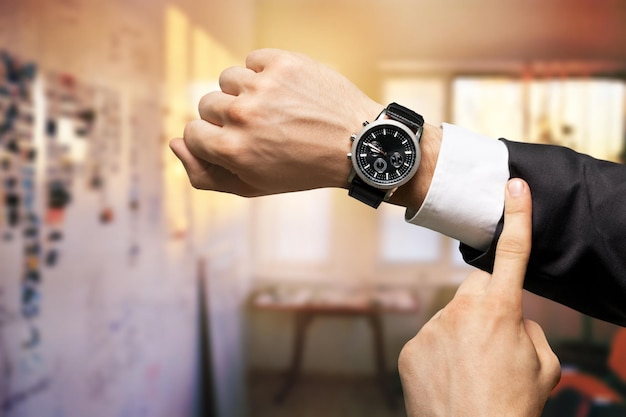 Businessman with hand watch on background, close-up