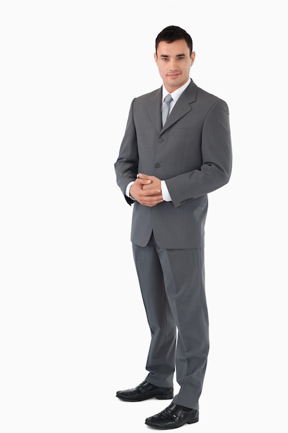 Businessman with hands folded against a white background