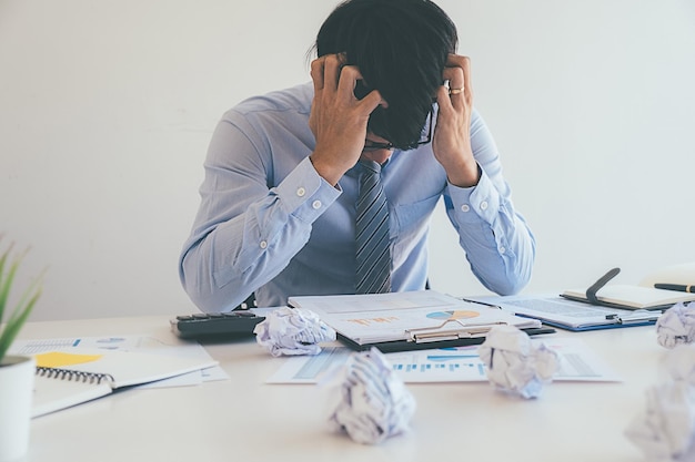 Businessman with head in hands sitting at desk