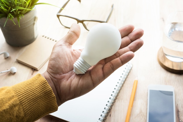 Businessman with lightbulb in workplace