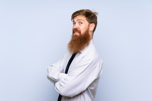 Businessman with long beard over isolated wall laughing